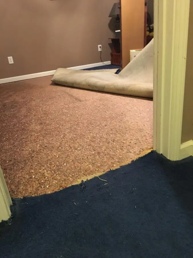 Carpet pad removal revealing water damage during Water Mitigation Services in Kearney